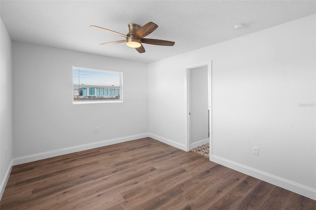 empty room with dark hardwood / wood-style floors and ceiling fan