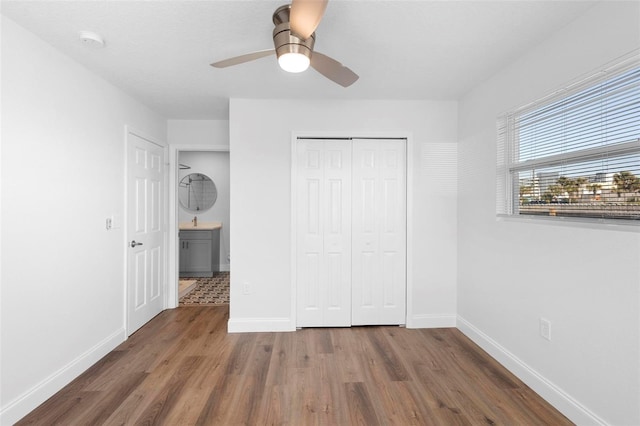 unfurnished bedroom with dark wood-type flooring, ceiling fan, and a closet