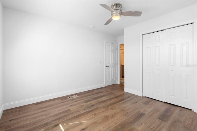 unfurnished bedroom with ceiling fan, dark hardwood / wood-style flooring, and a closet