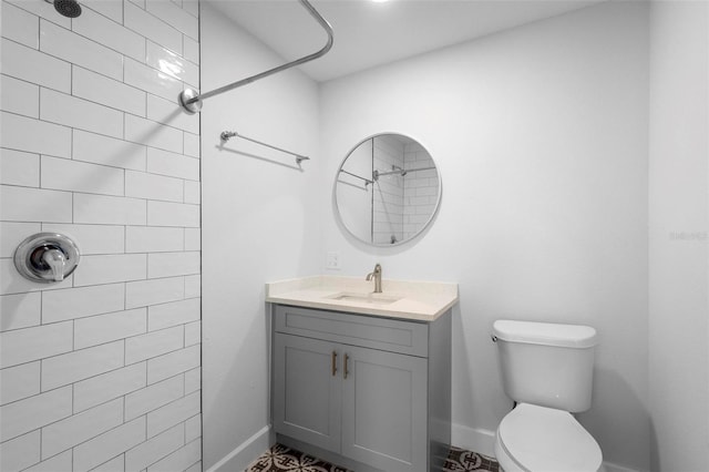 bathroom featuring vanity, toilet, and a tile shower