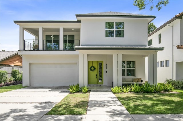 view of front of house with covered porch, stucco siding, a balcony, an attached garage, and concrete driveway