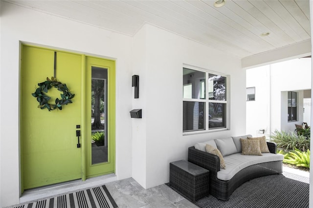 doorway to property with outdoor lounge area and stucco siding