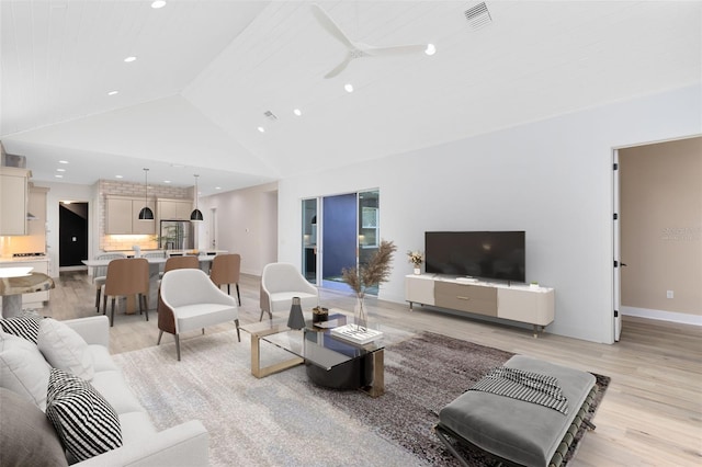 living room with high vaulted ceiling, light hardwood / wood-style floors, and ceiling fan