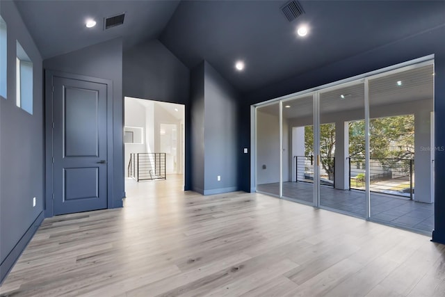 unfurnished room featuring high vaulted ceiling and light hardwood / wood-style flooring