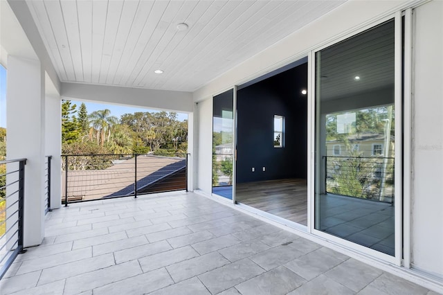 unfurnished sunroom featuring wood ceiling and vaulted ceiling