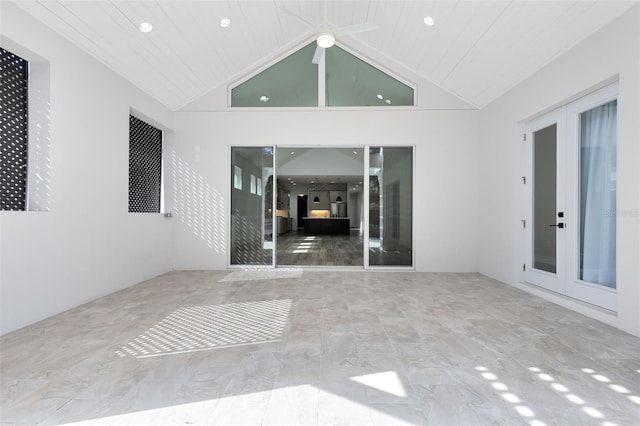 unfurnished room featuring french doors and high vaulted ceiling