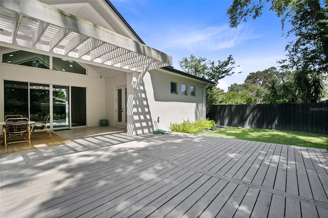 deck featuring a pergola, a yard, and fence