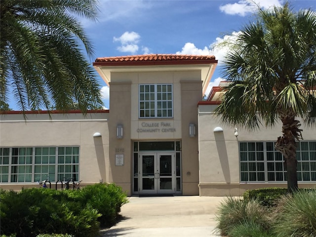 view of exterior entry with french doors and stucco siding