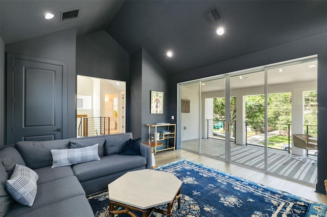 living room featuring recessed lighting, visible vents, light wood-type flooring, and vaulted ceiling