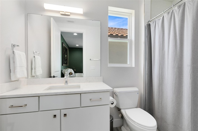 bathroom with a shower with shower curtain, vanity, and toilet