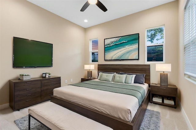 bedroom featuring baseboards, light colored carpet, and multiple windows