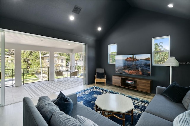 living area with high vaulted ceiling, recessed lighting, visible vents, and wood finished floors