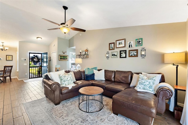 living room featuring lofted ceiling and ceiling fan with notable chandelier