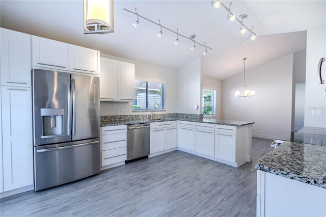 kitchen with lofted ceiling, sink, white cabinetry, stainless steel appliances, and kitchen peninsula