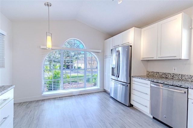 kitchen featuring vaulted ceiling, appliances with stainless steel finishes, pendant lighting, white cabinetry, and light stone counters