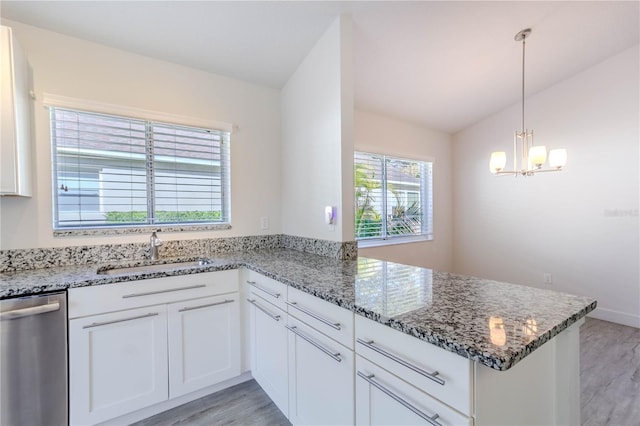 kitchen with stainless steel dishwasher, kitchen peninsula, sink, and white cabinets