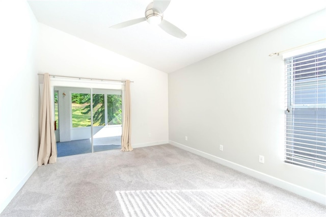 carpeted spare room featuring ceiling fan and vaulted ceiling