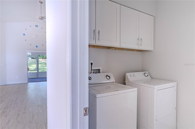 washroom featuring cabinets, washer and clothes dryer, and light hardwood / wood-style floors