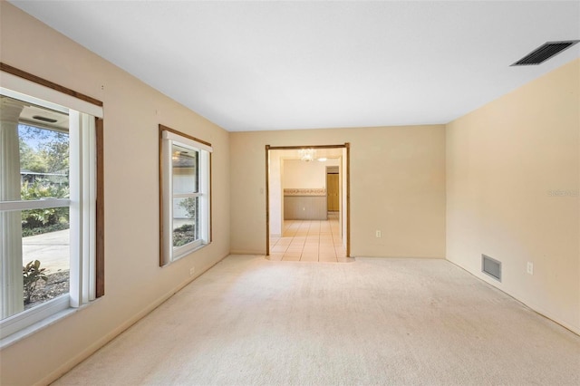 empty room featuring plenty of natural light and light carpet