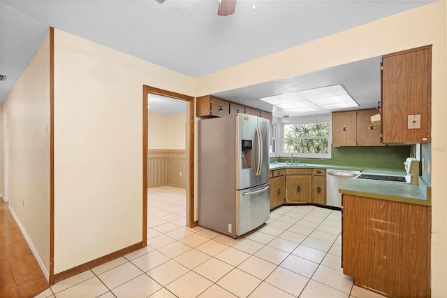 kitchen featuring light tile patterned floors, ceiling fan, stove, stainless steel refrigerator with ice dispenser, and white dishwasher