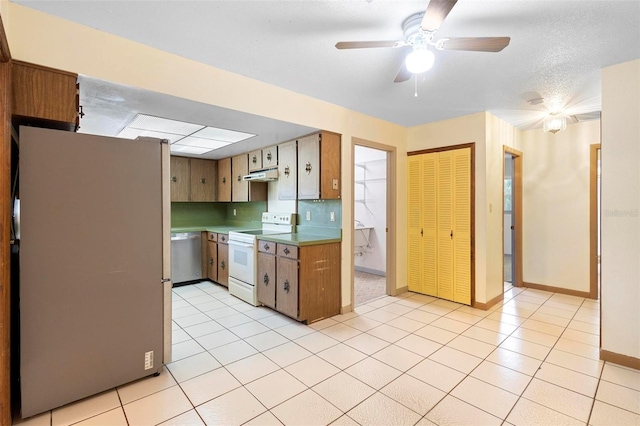 kitchen with ceiling fan, stainless steel appliances, decorative backsplash, and light tile patterned floors