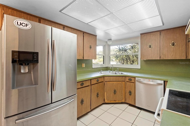 kitchen with appliances with stainless steel finishes, sink, and light tile patterned floors