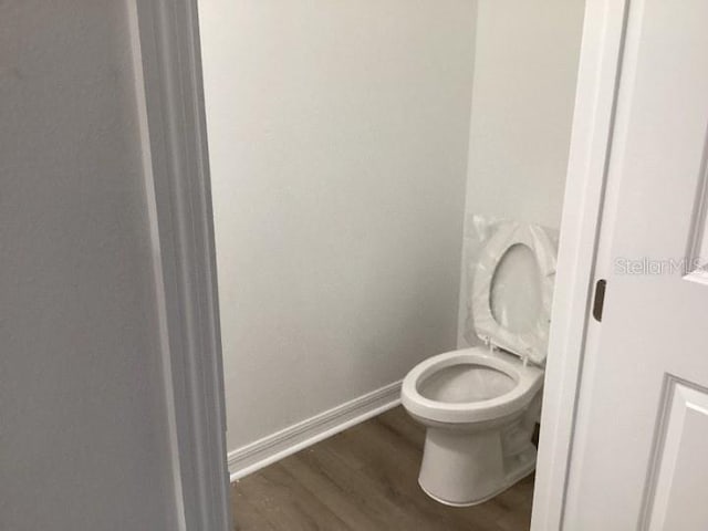 bathroom featuring hardwood / wood-style floors and toilet