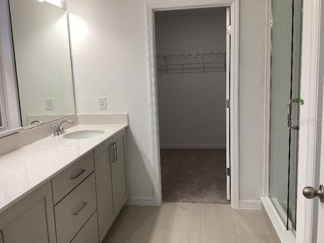 bathroom featuring vanity, a shower with door, and tile patterned floors