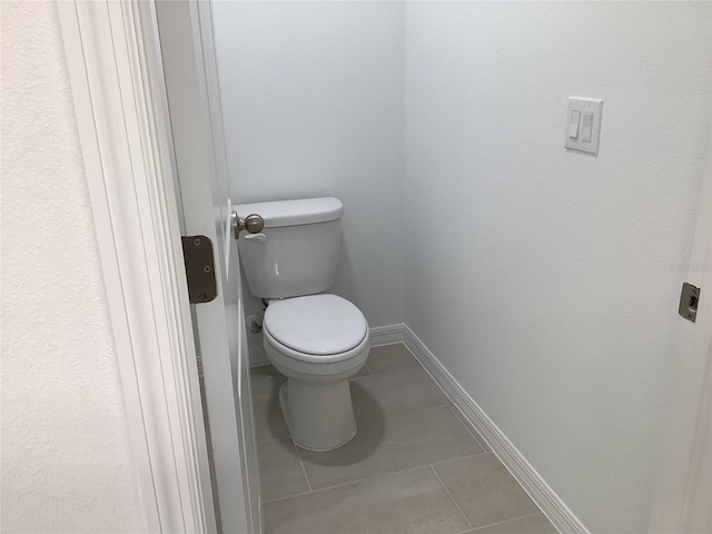 bathroom with toilet and tile patterned flooring