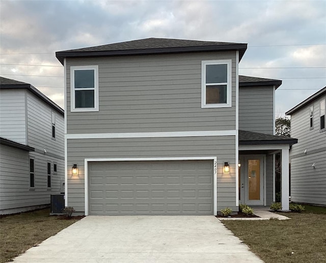 view of property featuring a garage, a front lawn, and central air condition unit