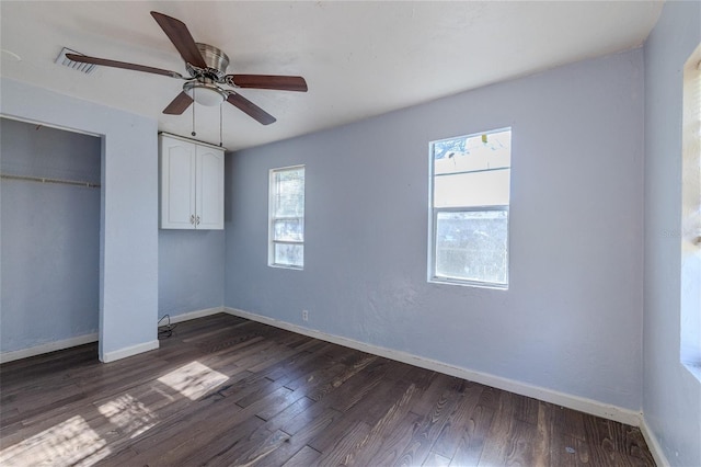 unfurnished bedroom featuring ceiling fan, dark hardwood / wood-style flooring, and a closet