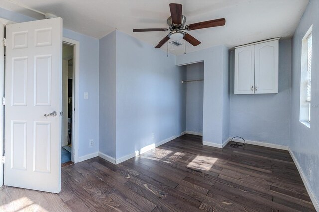 unfurnished bedroom with ceiling fan, dark hardwood / wood-style flooring, and a closet