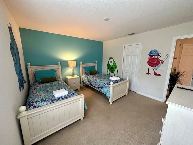 carpeted bedroom featuring a closet and a textured ceiling