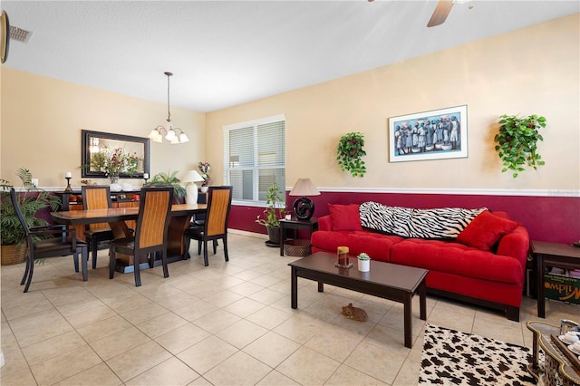 living room with ceiling fan with notable chandelier and light tile patterned flooring