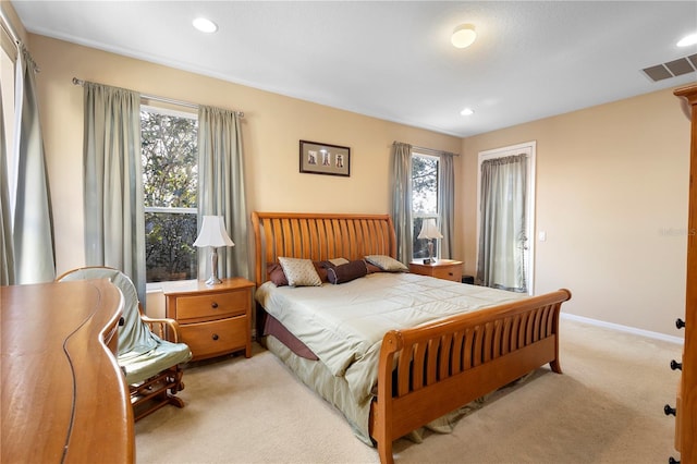 bedroom with multiple windows and light carpet