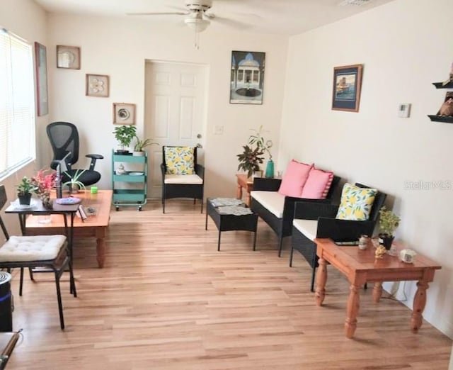 living area with ceiling fan and light wood-type flooring