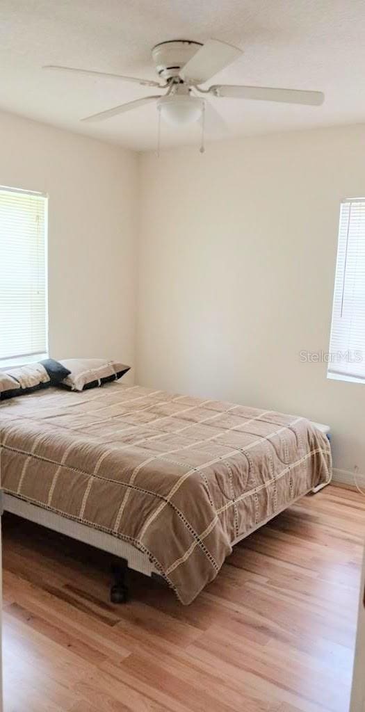 bedroom with ceiling fan and wood finished floors