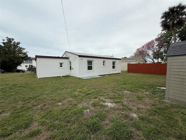 back of property featuring a yard and fence