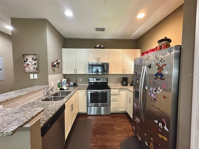 kitchen with white cabinetry, light stone countertops, kitchen peninsula, and appliances with stainless steel finishes