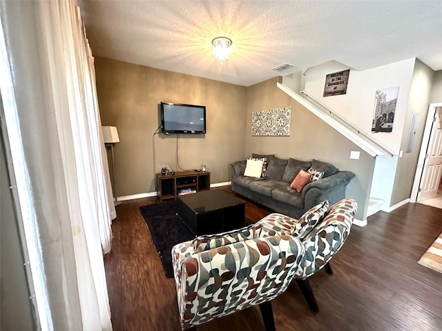 living room with dark hardwood / wood-style floors and a textured ceiling