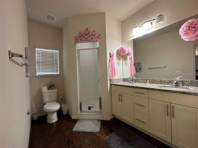 bathroom featuring vanity, toilet, a shower with shower door, and hardwood / wood-style floors