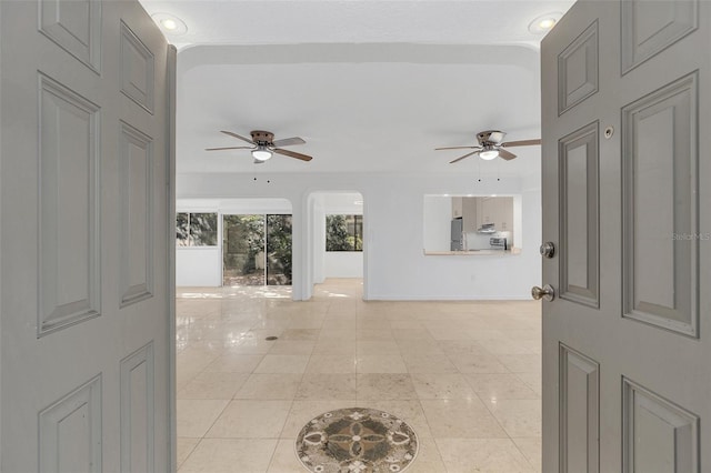 interior space featuring light tile patterned floors and arched walkways