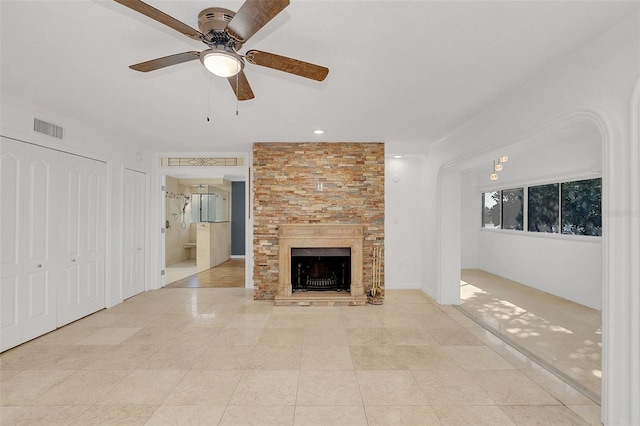 unfurnished living room featuring light tile patterned flooring, a large fireplace, a ceiling fan, and visible vents