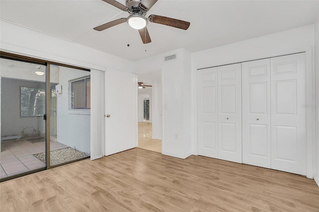 unfurnished bedroom with visible vents, ceiling fan, light wood finished floors, and a closet