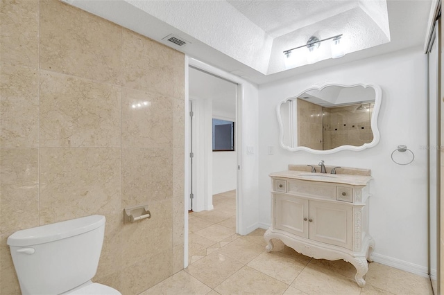 bathroom featuring a textured ceiling, vanity, visible vents, toilet, and tile patterned floors