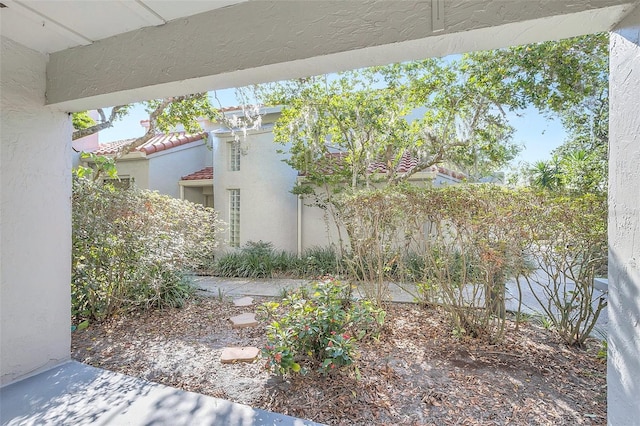 view of side of home featuring a tiled roof and stucco siding