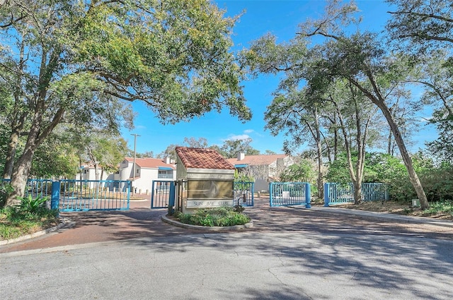 exterior space featuring a gated entry, curbs, and a gate