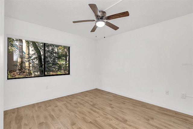 empty room with ceiling fan, wood finished floors, and baseboards