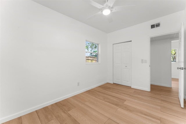 unfurnished bedroom with ceiling fan, light hardwood / wood-style floors, and a closet