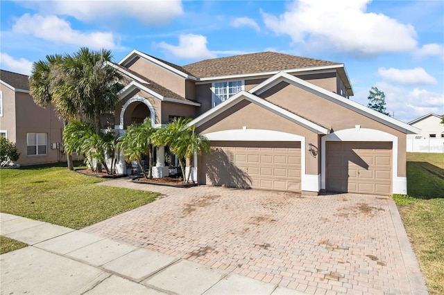 view of property with a garage and a front yard